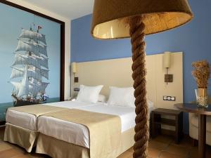 a bedroom with a bed with a pirate ship on the wall at Hotel Albaida Nature in Mazagón