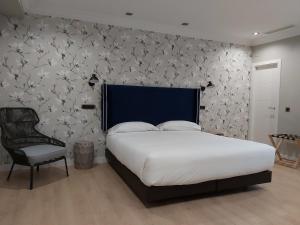 um quarto com uma cama grande e uma cadeira em Micampus Burgos Centro em Burgos