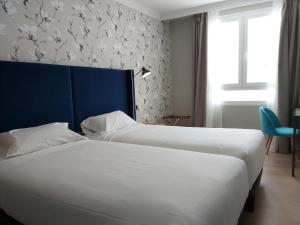 a hotel room with two beds and a window at Micampus Burgos Centro in Burgos