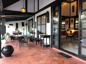 a patio with tables and chairs in a building at Pousada do Adriano in Búzios