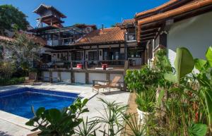 a house with a swimming pool in the yard at Pousada do Adriano in Búzios