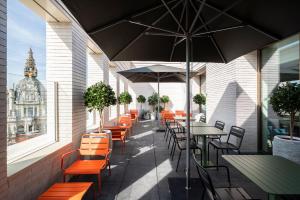 an outdoor patio with tables and chairs and an umbrella at B&B HOTEL Antwerpen Centrum in Antwerp
