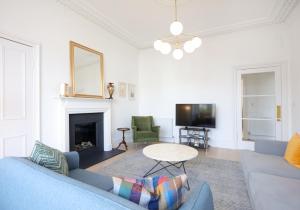 a living room with a blue couch and a fireplace at Sandacres in North Berwick