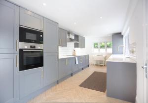 a kitchen with blue cabinets and a white counter top at Sandacres in North Berwick