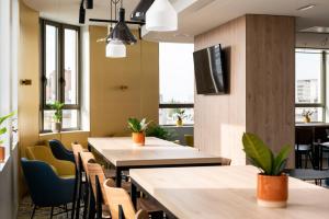a restaurant with tables and chairs and windows at B&B HOTEL Antwerpen Centrum in Antwerp