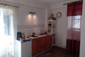 a kitchen with a sink and a clock on the wall at Studio Askanova in Valle Gran Rey