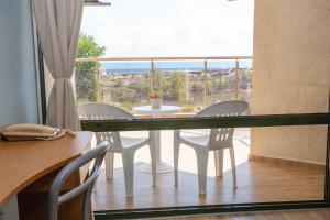 ein Esszimmer mit Tisch und Stühlen und einem großen Fenster in der Unterkunft Amfibia Beach Complex in Sonnenstrand