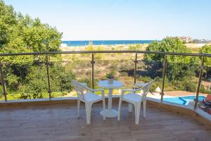 una mesa y sillas en un balcón con vistas en Amfibia Beach Complex, en Sunny Beach