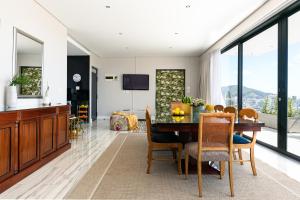 a kitchen and dining room with a table and chairs at Cambridge Suites -#1 Spectacular Balcony in Cape Town