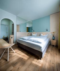 a bedroom with a large white bed and a table at Gartenhotel Fettehenne in Erkrath