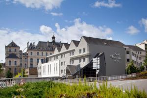 ein großes weißes Gebäude vor einem großen Gebäude in der Unterkunft Escale Oceania Vannes Centre in Vannes