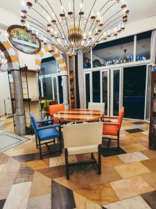 una sala da pranzo con tavolo, sedie e lampadario pendente di Damask Rose, Lebanese Guest House a Jounieh