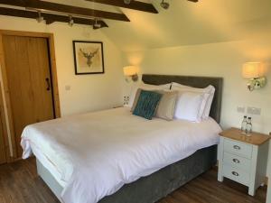 - une chambre avec un grand lit blanc et une table de nuit dans l'établissement Stunning Estate sleeps 22 private parking & garden, à Hailsham