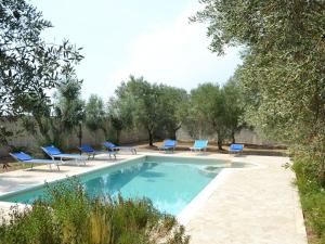 Vaste的住宿－Villa Baxta by Interhome，一个带蓝色躺椅和树木的游泳池