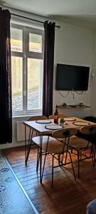 a living room with a table and chairs and a tv at Wimereux 30m2 1 chambre et 1 canapé lit à 2 pas de la plage et du centre in Wimereux