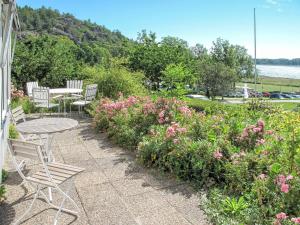 a patio with a table and chairs and flowers at Holiday Home Stegeborg Sjöstugan by Interhome in Norrkrog