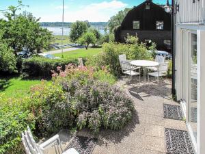 a patio with chairs and a table and flowers at Holiday Home Stegeborg Sjöstugan - OST104 by Interhome in Norrkrog