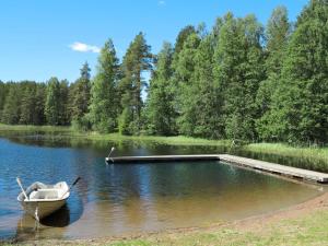 un barco sentado en el agua junto a un muelle en Chalet Nedre Gärdsjö - DAN085 by Interhome, en Rättvik