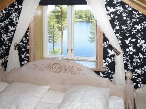 a bedroom with a bed and a window with a view at Chalet Nedre Gärdsjö - DAN085 by Interhome in Rättvik