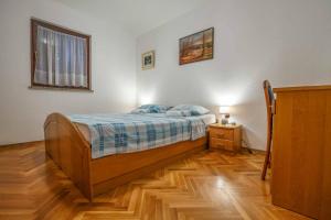 sypialnia z łóżkiem i drewnianą podłogą w obiekcie Apartman Mauro w mieście Malinska