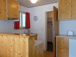 een keuken met houten kasten en een spoelbak bij Apartment Chalet Holzwurm-1 by Interhome in Grindelwald