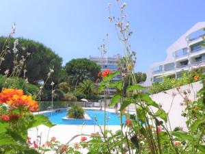 uma vista para uma piscina com flores em Apartment Fleurie I by Interhome em La Grande-Motte