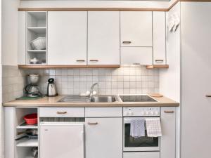 グリンデルワルトにあるApartment Chalet Abendrot-6 by Interhomeの白いキャビネットとシンク付きのキッチン
