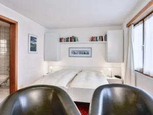 a bedroom with two black chairs and a bed at Apartment Chalet Abendrot-6 by Interhome in Grindelwald