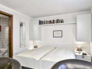 グリンデルワルトにあるApartment Chalet Abendrot-5 by Interhomeの白いベッドルーム(ベッド1台、バスルーム付)