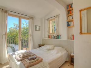 a bedroom with a bed and a large window at Holiday Home Les Cairnes by Interhome in Viens