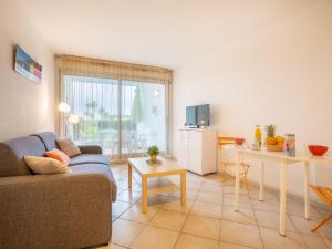 a living room with a couch and a table at Apartment Les Belles Plages-5 by Interhome in La Grande Motte