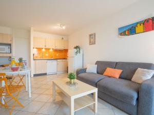 sala de estar con sofá, mesa y cocina en Apartment Les Belles Plages-5 by Interhome, en La Grande-Motte