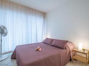 Un dormitorio con una cama morada con una caja rosa. en Apartment Les Belles Plages-5 by Interhome, en La Grande-Motte