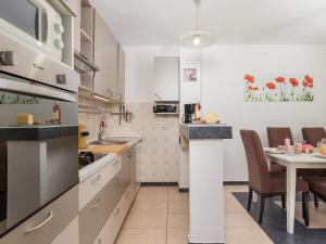a kitchen with white cabinets and a table with chairs at Holiday Home Kristijana by Interhome in Martina +23 photos