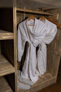 a closet filled with white clothes and shoes at Lodges des Grands Chênes in Andelarrot