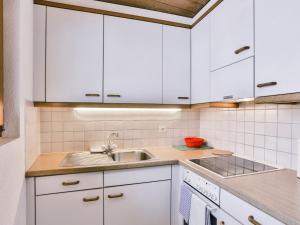 グリンデルワルトにあるApartment Chalet Abendrot-13 by Interhomeの白いキャビネットとシンク付きのキッチン
