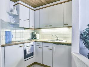 eine weiße Küche mit weißen Schränken und einem Waschbecken in der Unterkunft Apartment Chalet Abendrot-15 by Interhome in Grindelwald