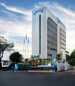 ein großes weißes Gebäude mit einem Schild davor in der Unterkunft Blue Sky Hotel Petamburan in Jakarta