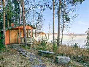 une cabane dans les bois avec un banc et un lac dans l'établissement Holiday Home Wilkkilä by Interhome, à Ruokola