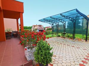 a greenhouse with red flowers on a patio at Holiday Home Marko by Interhome in Filipac