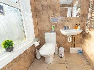 La salle de bains est pourvue de toilettes et d'un lavabo. dans l'établissement BellaLiving 2 Bedroom Apartment - Luton, à Luton