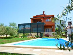 a villa with a swimming pool in front of a house at Holiday Home Marko by Interhome in Filipac