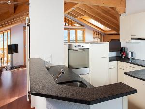 eine Küche mit einer Spüle und einer Arbeitsplatte in der Unterkunft Apartment Chalet Tuftstein by Interhome in Grindelwald