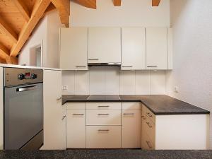 eine Küche mit weißen Schränken und einer Arbeitsplatte in der Unterkunft Apartment Chalet Tuftstein by Interhome in Grindelwald