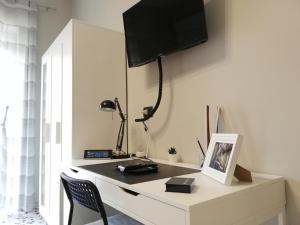 Cette chambre comprend un bureau et une télévision. dans l'établissement AliceA apartment in Siracusa, à Syracuse