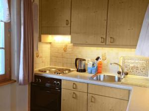 een keuken met een wastafel en een fornuis bij Apartment Lohnerhus-1 by Interhome in Grindelwald
