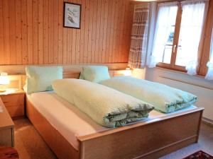 een bed in een kamer met twee kussens erop bij Apartment Lohnerhus-1 by Interhome in Grindelwald