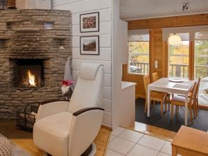 ein Wohnzimmer mit Kamin und ein Esszimmer in der Unterkunft Holiday Home Vuosseli-kelkka 15a by Interhome in Ruka