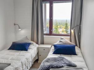 een slaapkamer met 2 bedden en een groot raam bij Holiday Home Villa ylläs 203 by Interhome in Ylläs