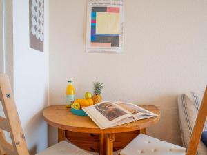 ラ・グランド・モットにあるStudio Les Belles Plages-6 by Interhomeの本と果物を載せたテーブル